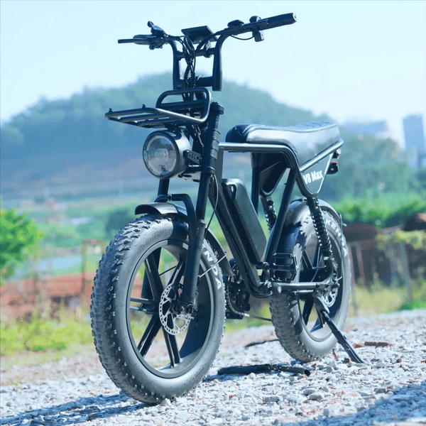 Zwarte AtlasTrek V8 Max elektrische fatbike getoond vanuit een driekwart vooraanzicht buiten op een grindpad