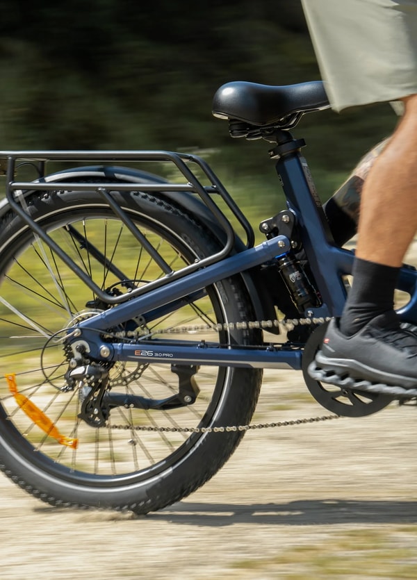 Engwe E26 3.0 Pro voorwiel close-up die de fatbike band, de voorvork, de voorste schijfrem en de reflector naast een meer toont