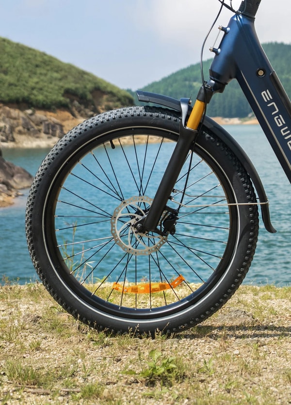Twee rijders met helm op Engwe E26 3.0 Pro elektrische fietsen die langs een bergweg reizen