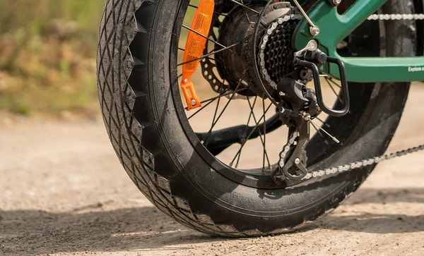 Engwe EP-2 3.0 Boost rear wheel close-up showing the wide treaded tire, orange reflector, chain and rear drivetrain