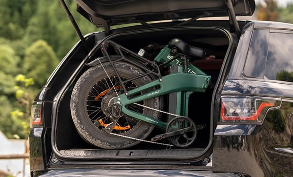 Engwe EP-2 3.0 Boost green folding electric fat bike folded inside the rear cargo area of a black vehicle