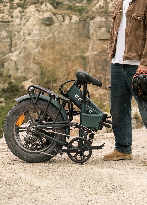 Engwe Engine Pro 2.0 opvouwbare elektrische fatbike buiten getoond naast een persoon, met nadruk op de bagagedrager, fatbike band, opvouwbaar frame en achtervering