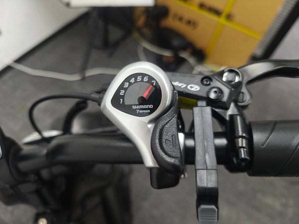 Close-up van de VOMO X70 Shimano 7-versnellingschakelaar en stuurbediening